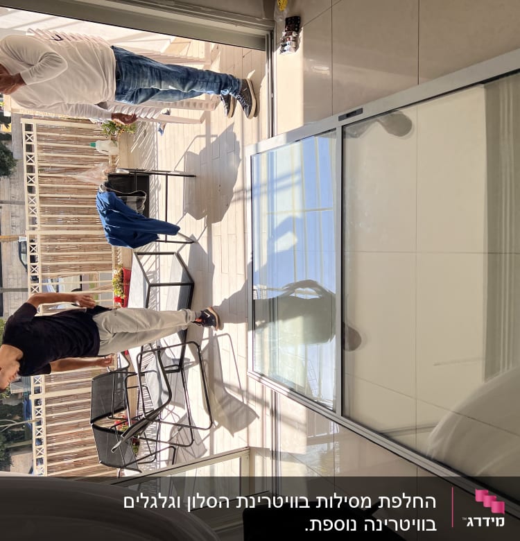 Large glass shutter lying on the floor with two people nearby.